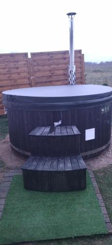 a hot tub with a table and stairs in a yard at Apartament Kornelia in Gołdap