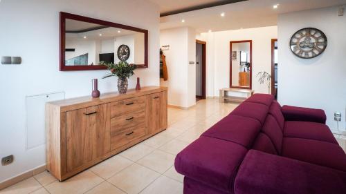 a living room with a purple couch and a mirror at Apartament Wschodnia in Lublin