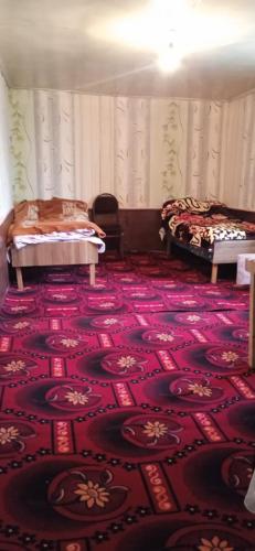 a room with two beds and a red carpet at AliveNino in Xınalıq