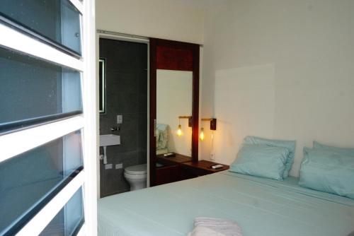 a white bedroom with a bed and a bathroom at Boca Simon Vacation Curacao in Willemstad