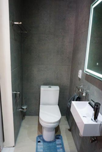 a bathroom with a white toilet and a sink at Boca Simon Vacation Curacao in Willemstad
