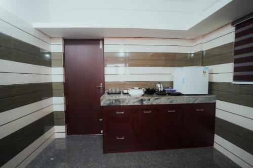 a kitchen with wood paneling and a counter top at BEVERLY SUITES in Wayanad