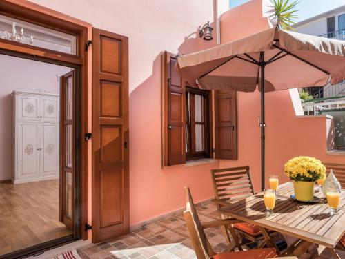 een houten tafel met een parasol op een patio bij Palazzo di Irene in Chania