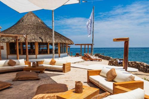 een resort op het strand met banken en een parasol bij Hotel Sunsets del Rosario in Isla Grande