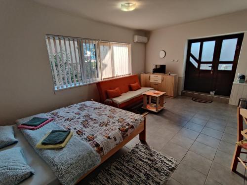 1 dormitorio con cama, sofá y ventana en Apartman Ankica, en Golubac