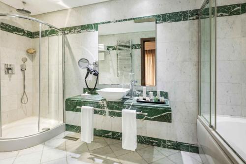 a bathroom with a tub and a sink and a shower at Hotel Çelik Palas Convention Center & Thermal SPA in Bursa
