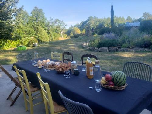 uma mesa azul com frutas e legumes em La Chabanade em Saint-Pierre-Eynac