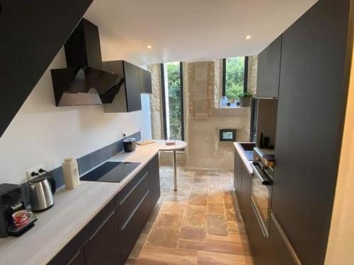 a kitchen with black and white counters and a table at Appartement centre-ville de Valognes in Valognes