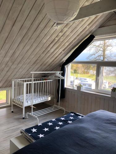 a bedroom with a bed and a crib in a room at Ferienhaus am Vänern mit Seeblick in Mariestad