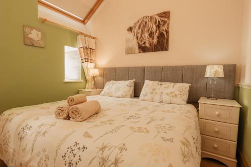 een slaapkamer met een bed met handdoeken erop bij Bennar Isa Cottages Dyffryn Ardudwy in Barmouth