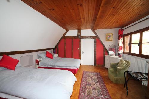 a bedroom with two beds and a chair in a room at Chez Robins in Trie-Château