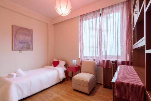 een kamer met 2 bedden, een stoel en een raam bij Acropolis View apartment 120sqm in Athene