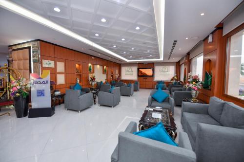 a waiting room with blue chairs in a building at Aseel Alsharq Hotel in Riyadh