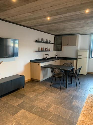 a kitchen with a table and chairs in a room at Vélo 94 bij Soof in Geel