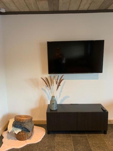 a room with a black table and a tv on a wall at Vélo 94 bij Soof in Geel