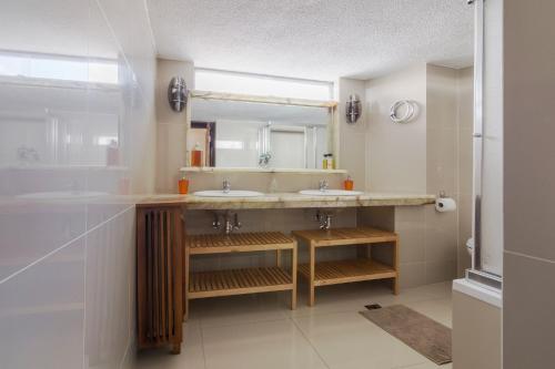 een badkamer met 2 wastafels en een grote spiegel bij Acropolis View apartment 120sqm in Athene