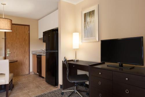 a room with a desk with a computer and a television at GreenTree Suites Eagle / Vail Valley in Eagle