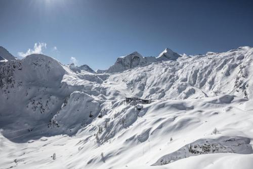 a mountain covered in snow with mountains in the background at Aurora Mountain Chalet by we rent, SUMMERCARD INCLUDED in Kaprun
