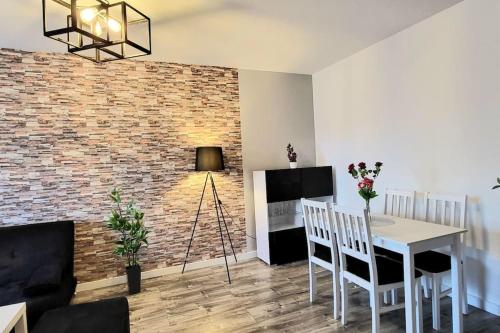 a living room with a table and chairs and a brick wall at Cozy RED ROSE Apartment, 2 rooms Down Town in Kraków
