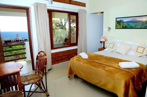a bedroom with a large bed and a balcony at Dr Nisha's Vedic Remedies in Trivandrum