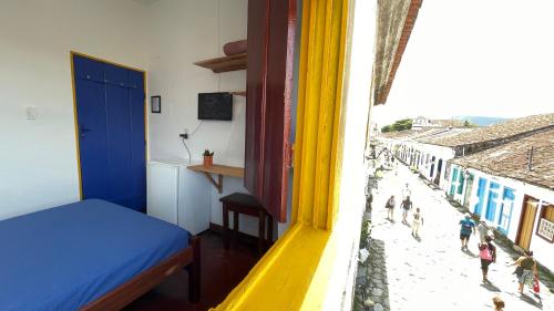 a room with a bed and a view of a street at Pousada Aquarium Centro Histórico in Paraty