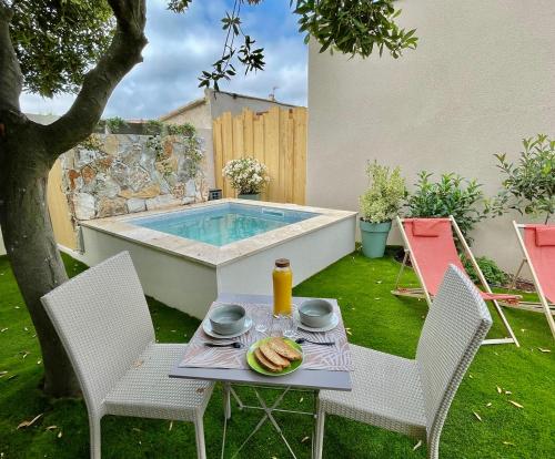 - une table avec une assiette de nourriture et une boisson dans l'établissement Studio Piscine Balnéo Chauffée, à Sérignan