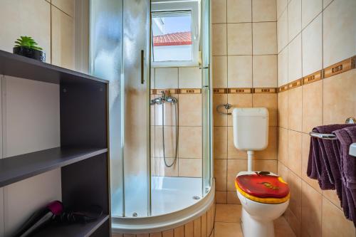 a bathroom with a toilet and a glass shower at Apartments Nina in Zadar