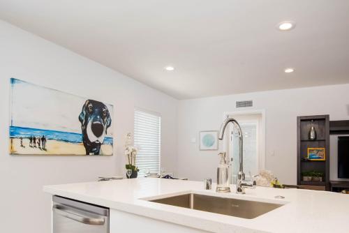 uma cozinha com um lavatório e uma pintura na parede em Hideaway Unit D em San Clemente