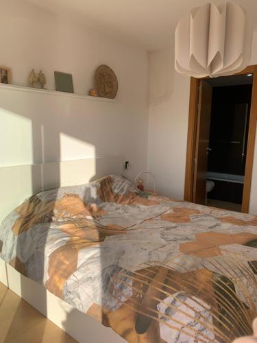 ein Schlafzimmer mit einem Bett mit einer bunten Bettdecke in der Unterkunft Apartment Sol Dorado - Mar Menor Golf Resort in Torre-Pacheco