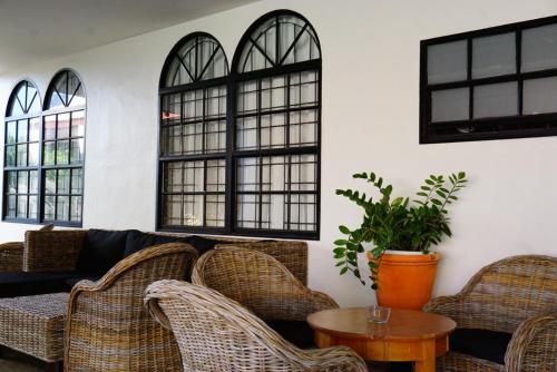 a living room with wicker chairs and a couch at Boca Simon Vacation Curacao in Willemstad