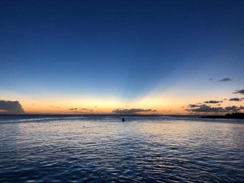 a person swimming in the water at sunset at Boca Simon Vacation Curacao in Willemstad