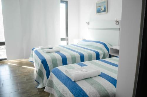 two beds in a room with blue and white stripes at JAK Colón in Colón