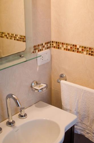 a bathroom with a sink and a mirror and a towel at JAK Colón in Colón