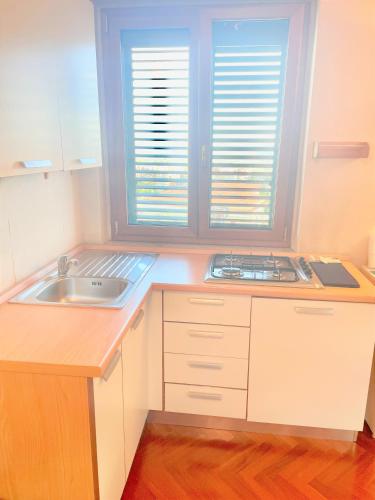 una piccola cucina con lavandino e finestra di Maison 26 Campobasso a Campobasso