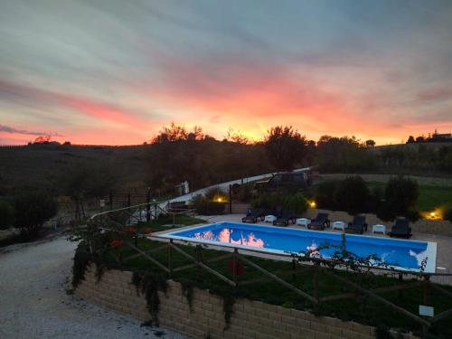 a swimming pool with a sunset in the background at AFFITTACAMERE LA QUIETE in San Marcello