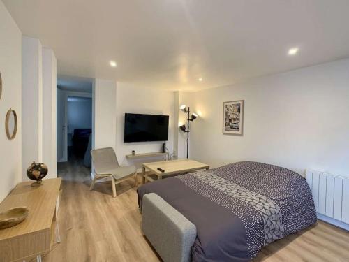 une chambre avec un lit, un bureau et une télévision dans l'établissement Appartement moderne avec parking gratuit, à Dinsheim
