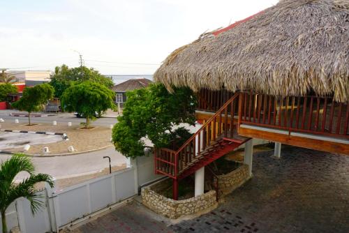 a building with a thatch roof and a courtyard at Boca Simon Vacation Curacao in Willemstad