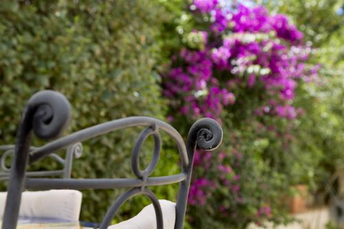 a metal bench in front of some pink flowers at BREZZA DEL CONERO in Ancona