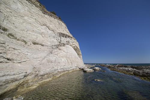 a large rock cliff next to the water at BREZZA DEL CONERO in Ancona