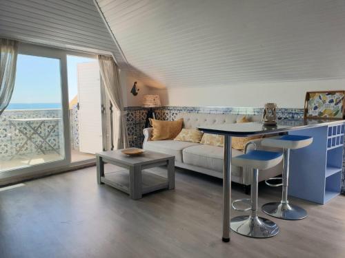 ein Wohnzimmer mit einem Sofa und einem Tisch in der Unterkunft BLUE HOUSE SESIMBRA with parking in Sesimbra