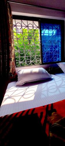 a bed in a room with a window at Nilam Guest House in Bodh Gaya