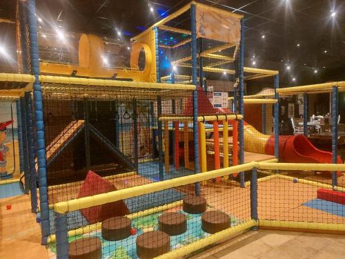a play room with a playground with a slide at Cosy Petten, Family only in Petten