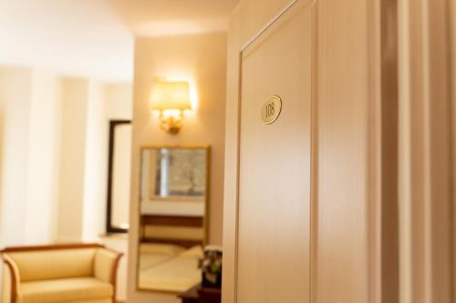 a door to a room with a chair and a mirror at Hotel Ristorante Vecchia Vibo in Vibo Valentia