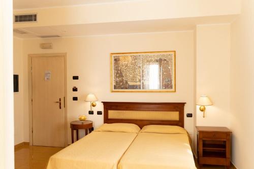 a bedroom with two beds and a picture on the wall at Hotel Ristorante Vecchia Vibo in Vibo Valentia