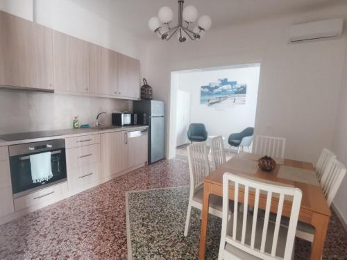 eine Küche und ein Esszimmer mit einem Tisch und Stühlen in der Unterkunft RODIES apartment in Chalkida