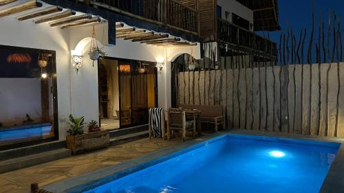 a swimming pool in front of a house at Chunga Changa in Matemwe