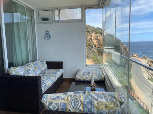 a living room with a couch and a view of the ocean at Una vista increíble al Pacifico in Concón