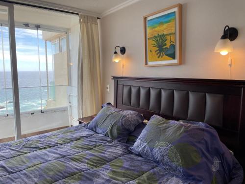 a bedroom with a bed with a view of the ocean at El Encanto del Pacífico a tus pies in Concón