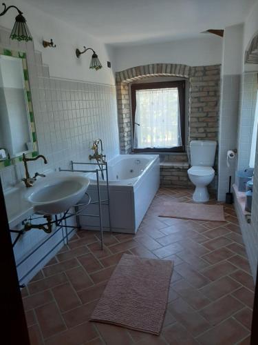a bathroom with a tub and a sink and a toilet at Bed & Breakfast Villa Monterosso in Sassoferrato