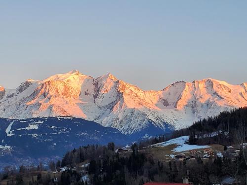 Blick auf eine Bergkette mit schneebedeckten Bergen in der Unterkunft Chalet à Cordon face à la chaîne du Mont Blanc in Cordon